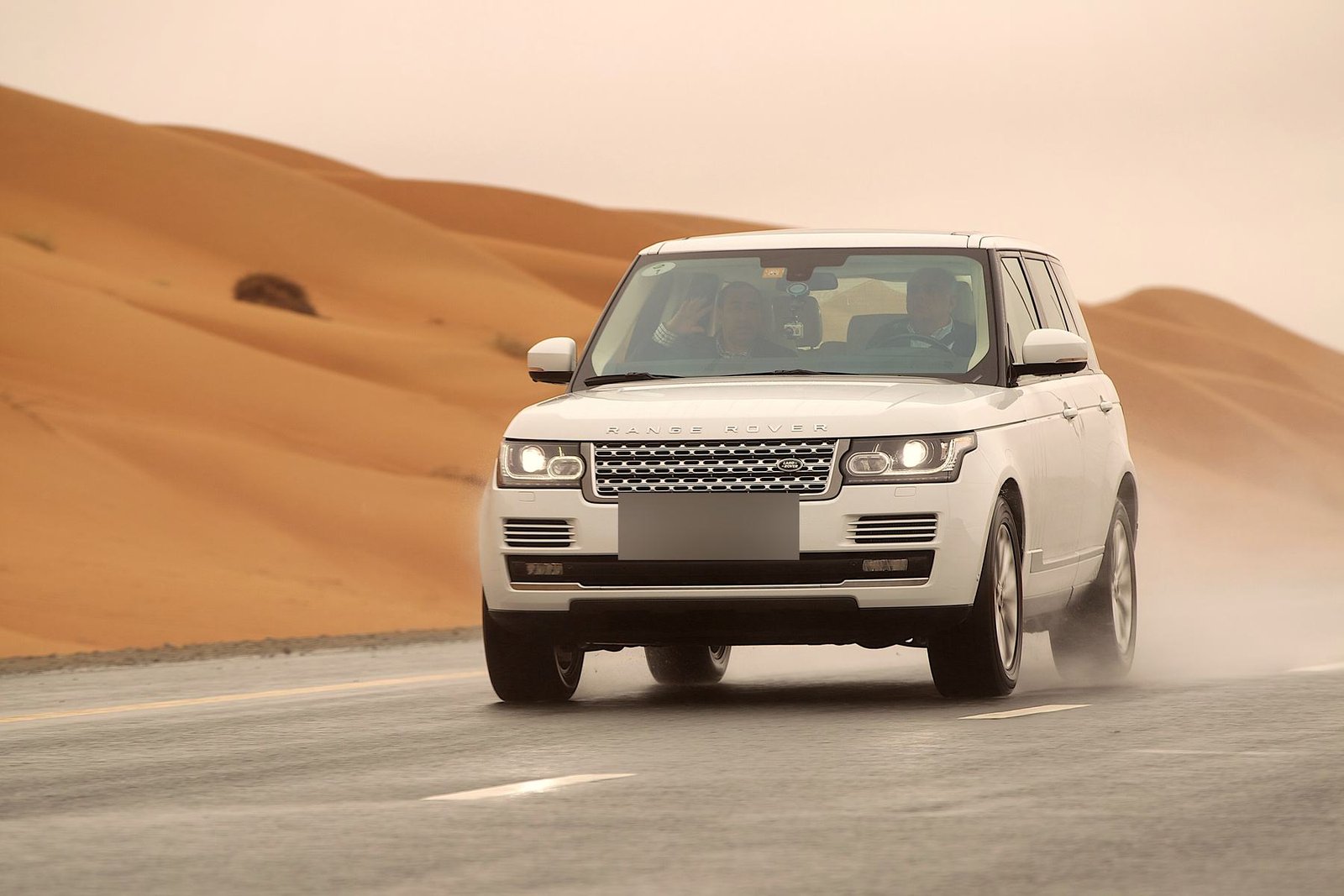 A white Range Rover crossing the desert